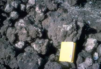 Photograph of ejecta with a notebook for scale