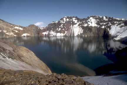 Photograph from caldera rim looking down at lake in crater