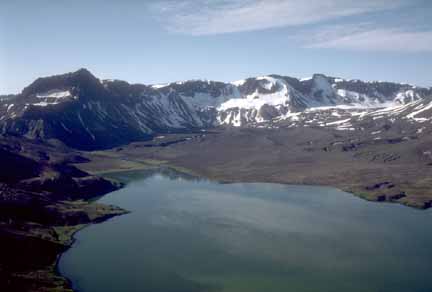 Photograph of lake in foreground; crater rim in background