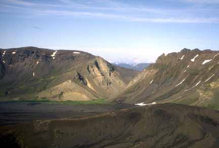 Photograph of  canyon cut in crater rim; cone in foreground