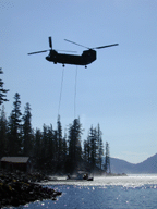 [Photo of helicopter attaching lines to boat at dock] 