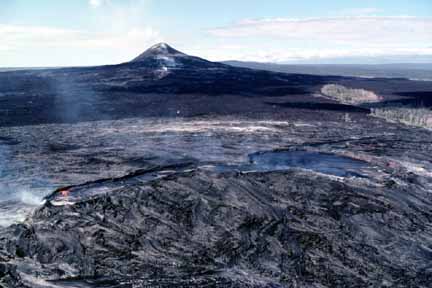 photo 038.  Low-elevation oblique aerial photo of small volcano in background and hot lava flows in foreground