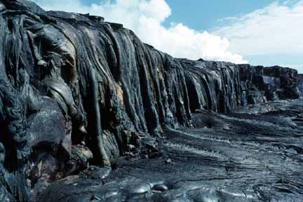 photo 047.  Photo of buttress with lava draped over it and along the base.  Drop is several meters tall