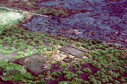 photo 053.  Low-elevation oblique aerial photo of lava flow near foundation of what used to be a structure