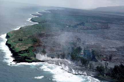 photo 070.  Low-elevation oblique aerial photo of lava flow; houses all burned up as lava fills in lagoon