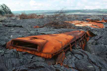 photo 079.  Photo of roof of burned-out yellow school bus peeking out of lava flow